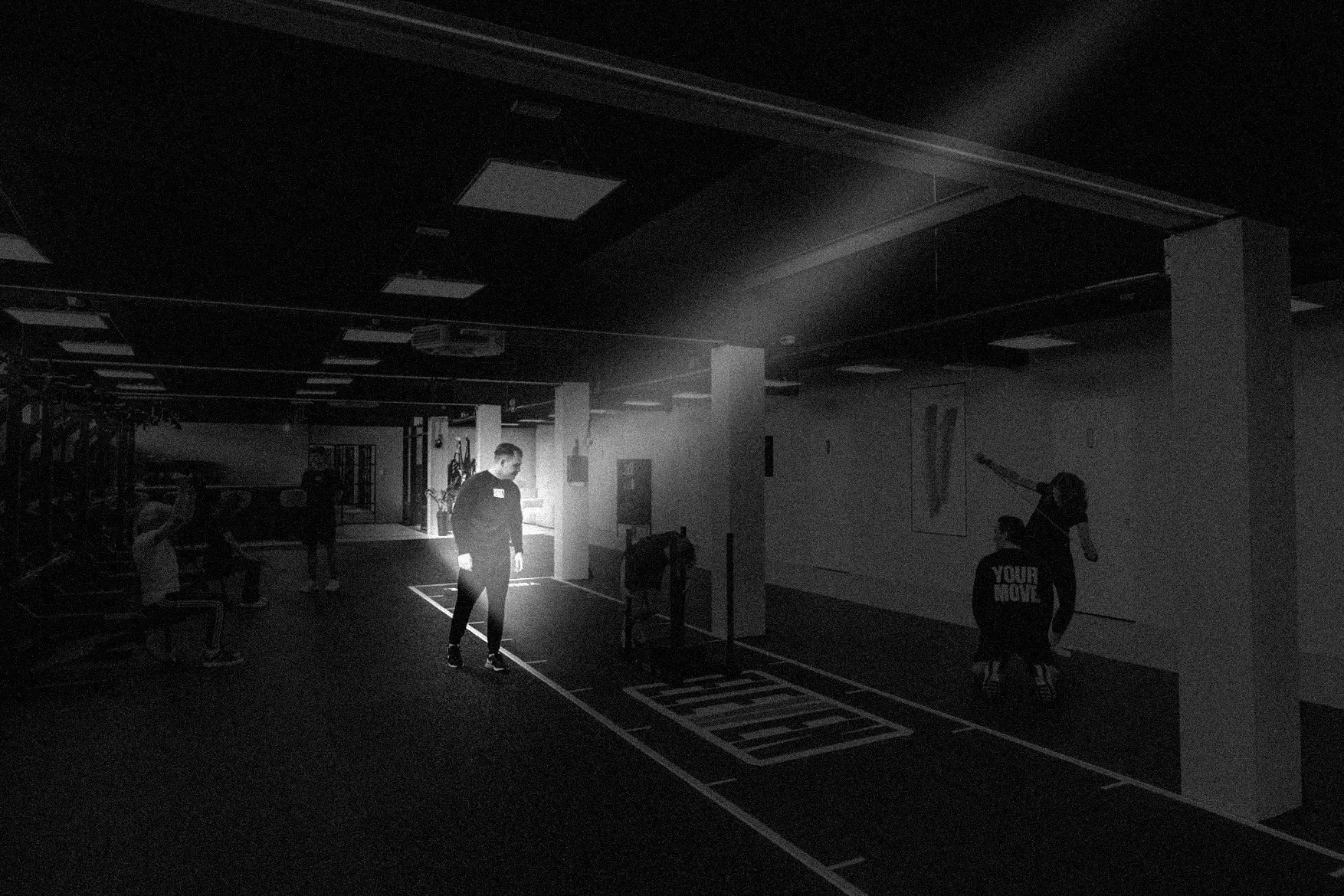 De trainingsvloer van ELEVEN, een lichtbundel valt op een sporter