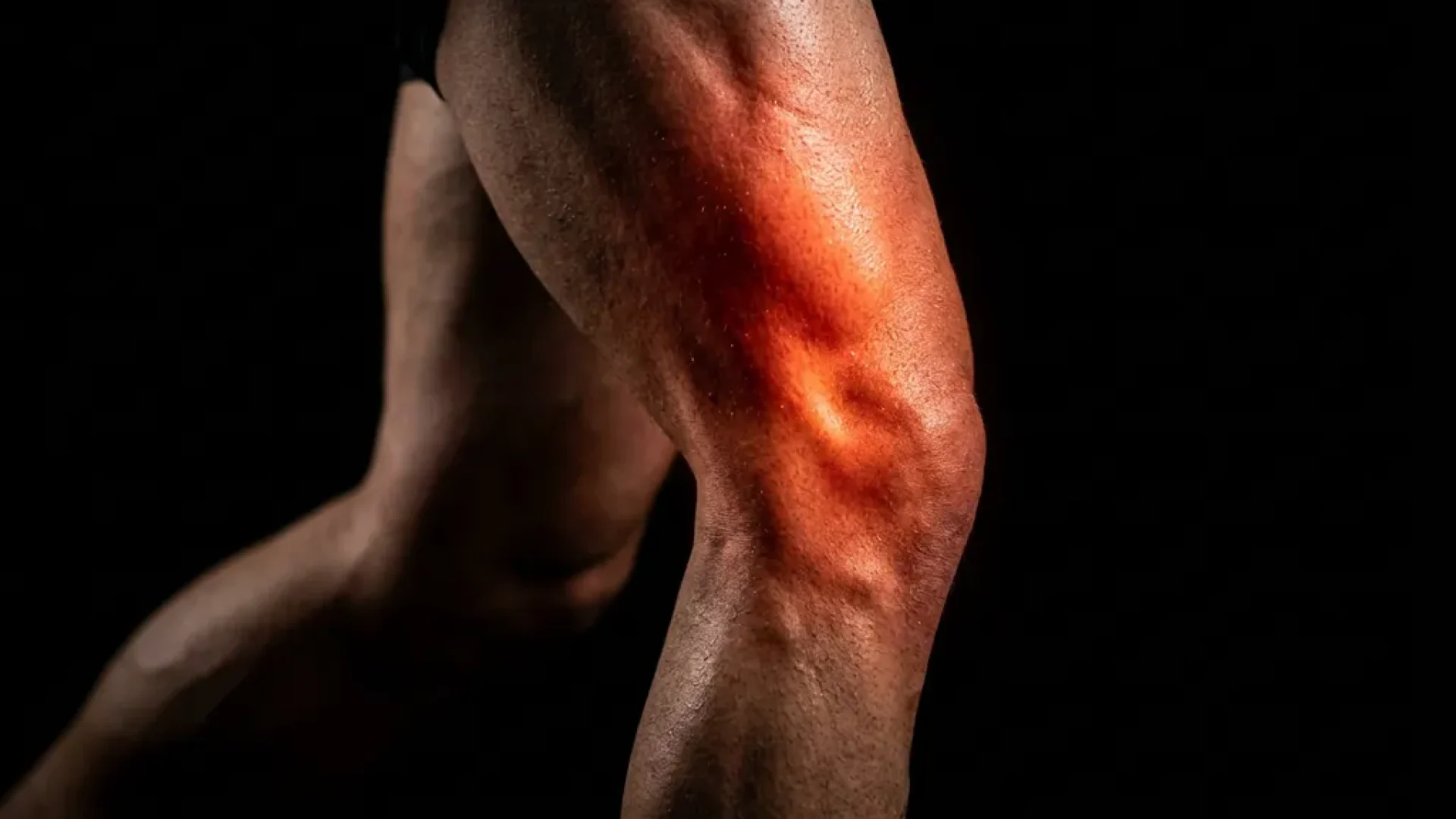 Atletisch been in beweging met gloeiende rode pijn in kniegewricht en quadriceps, zichtbaar op zwarte achtergrond.