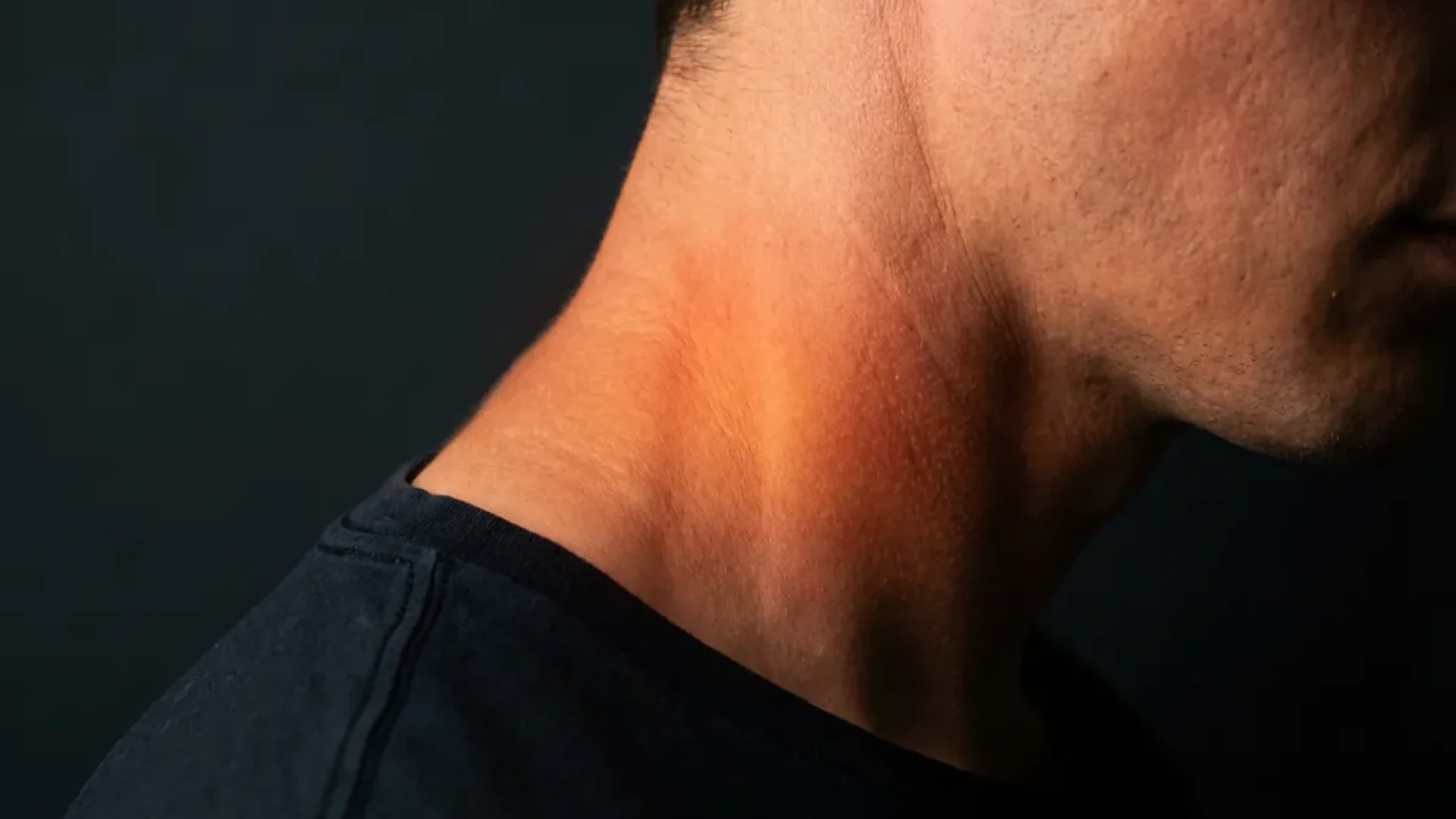 Nek en schouder met warme roodoranje gloed in cervicale wervelkolom die pijn en spanning visualiseert