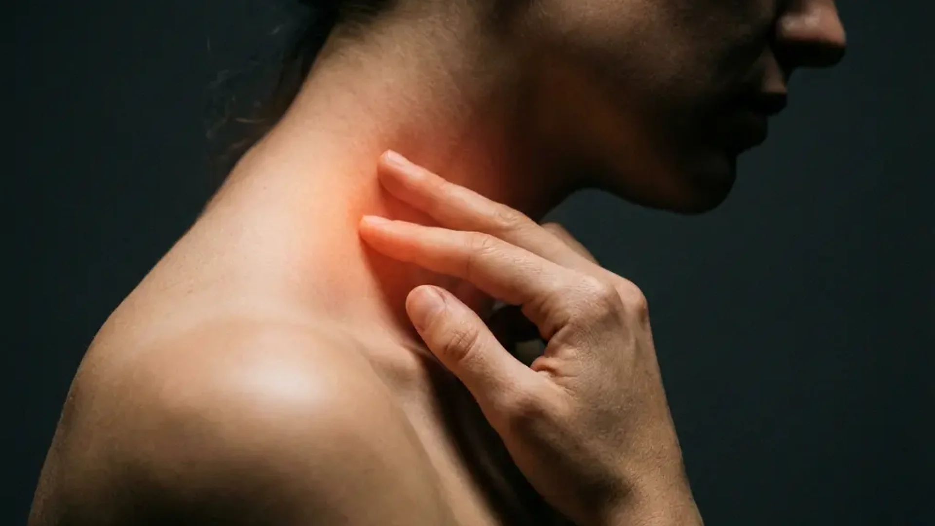 Persoon raakt nek aan met warme roodoranje gloed die pijn en spanning visualiseert tegen donkere achtergrond