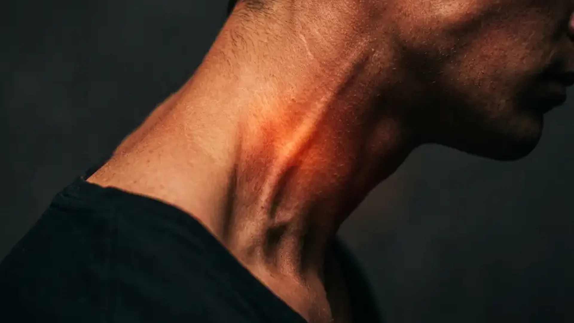 Persoon in profiel met gespannen nekspieren en roodoranje gloed die interne spanning in cervicale weefsels visualiseert