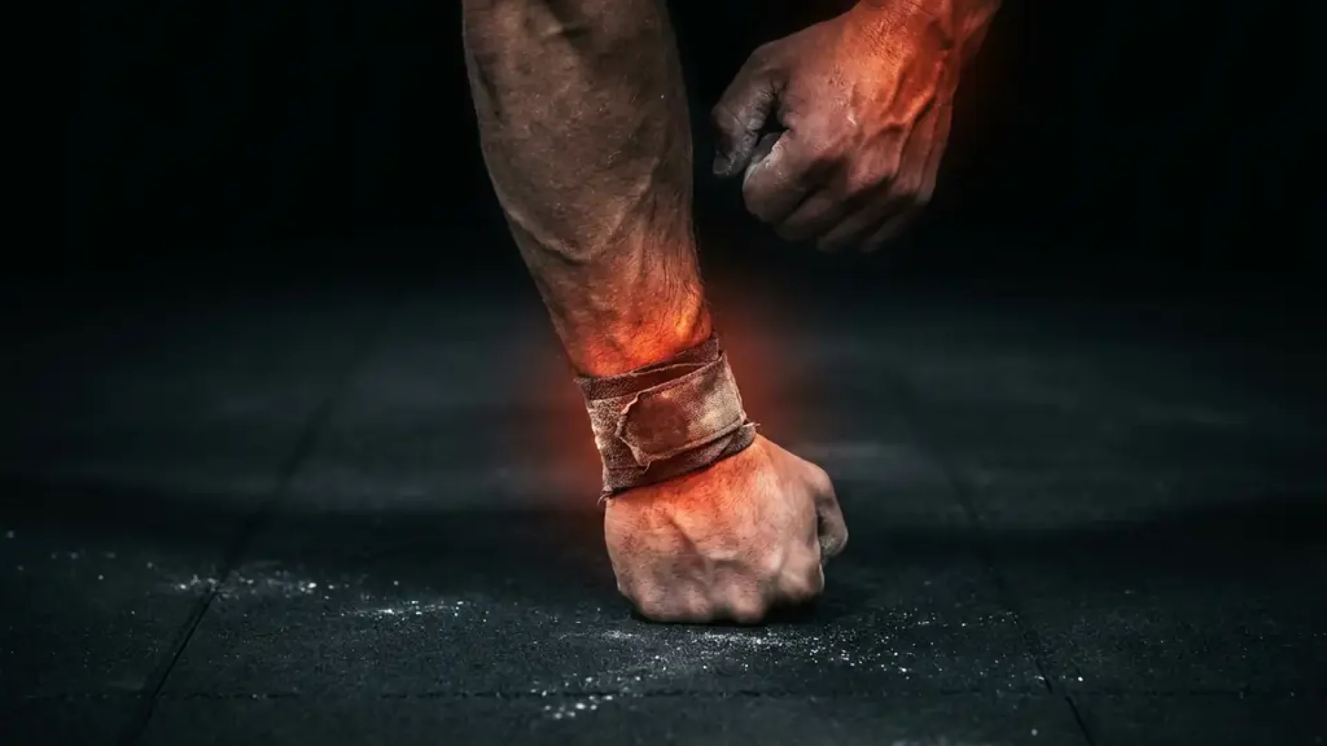 Gespierde onderarm en gebalde vuist op gymvloer tijdens push-up, met gloeiend amber-rood licht bij pols en schouderpeeszone.