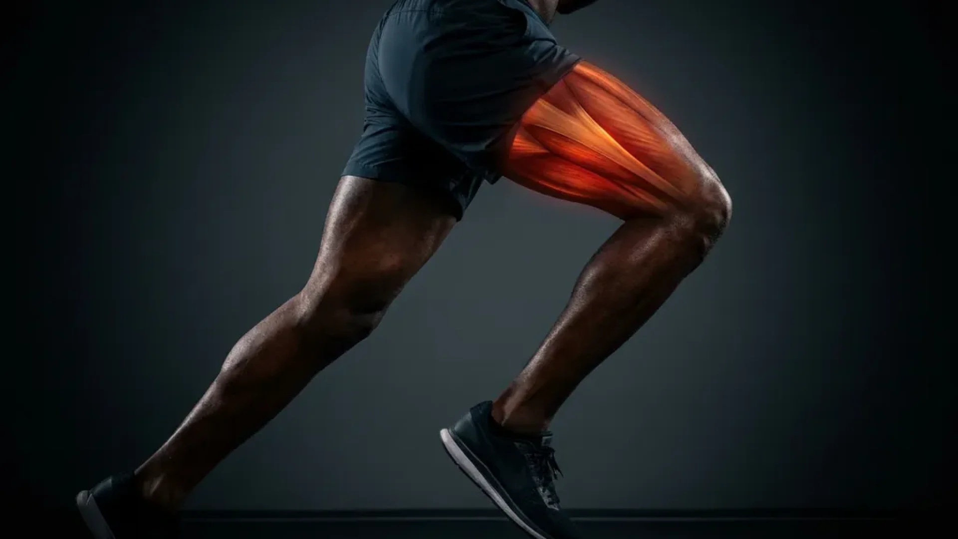 Gespierde atletenbenen in sprintstance met gloeiende rood-oranje warmte in quadriceps en heupbuigers op donkere achtergrond.